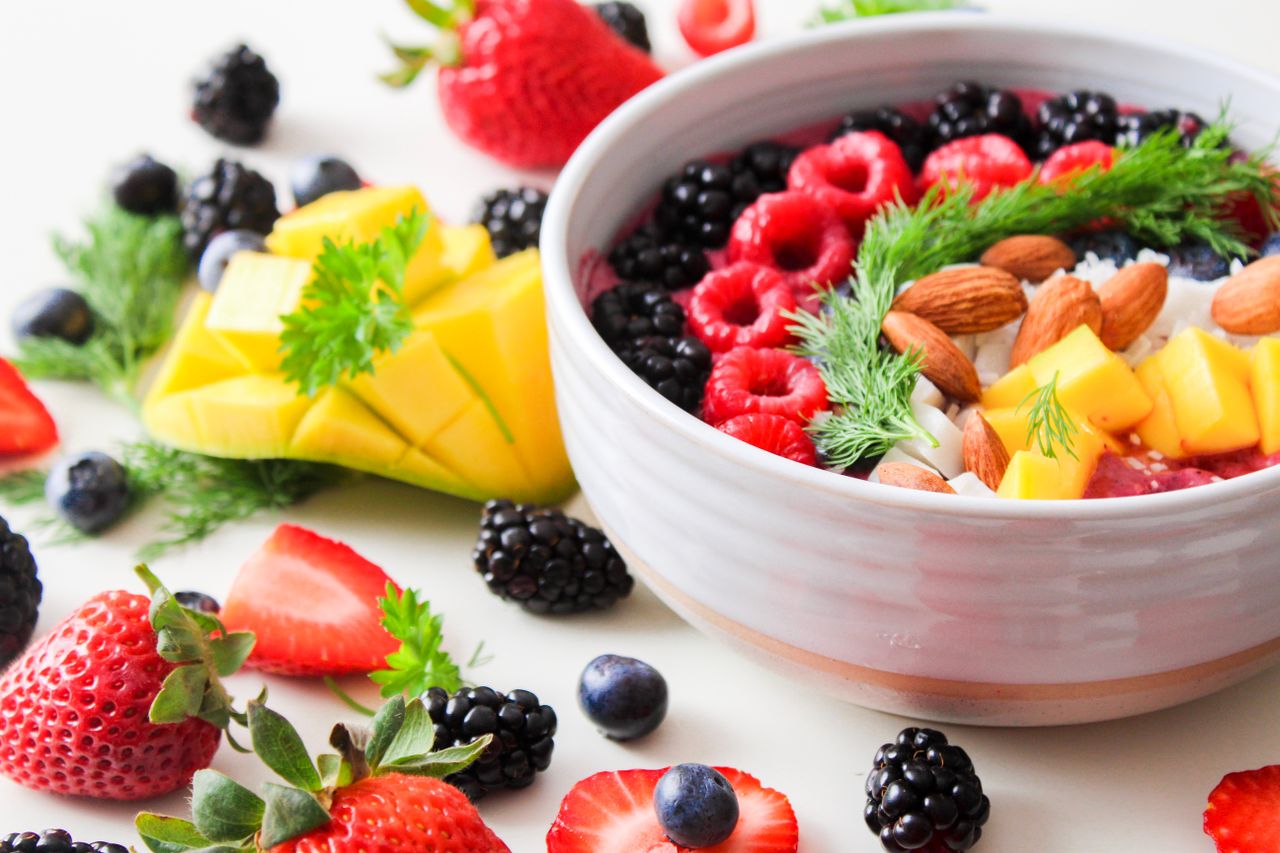 heros-img A vibrant bowl filled with fresh berries, mango, almonds, and herbs, perfect for a healthy snack or breakfast.