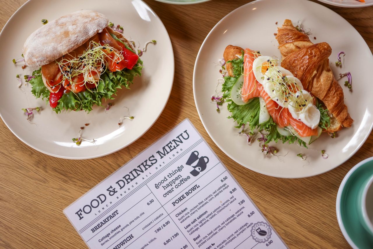 about-us-01 Top view of delicious salmon croissant and sandwich with fresh ingredients on wooden table.